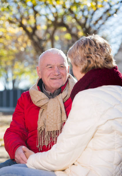 istock Mature couple talking in park 651337790