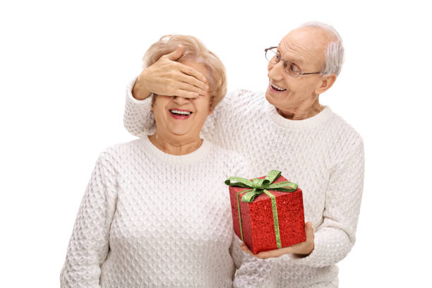 istock Elderly man surprising an elderly woman with a gift 651349222