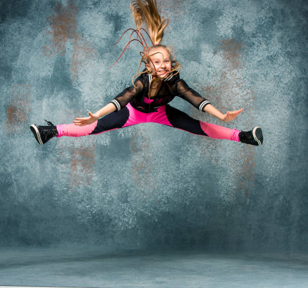 istock Young girl break dancing on wall background 651349284
