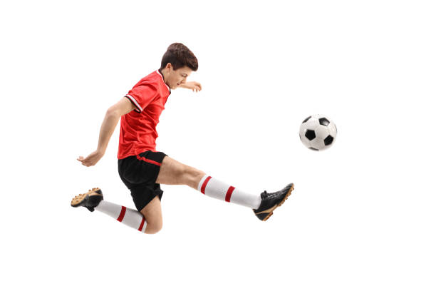 Teenage soccer player kicking a football Teenage soccer player kicking a football isolated on white background kicking photos stock pictures, royalty-free photos & images