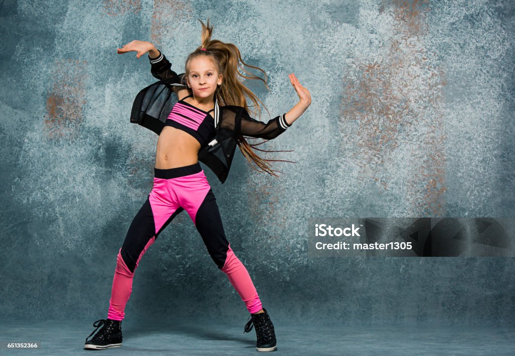 Young girl break dancing on wall background Young girl break dancing on gray wall stidio background. Dancing Stock Photo