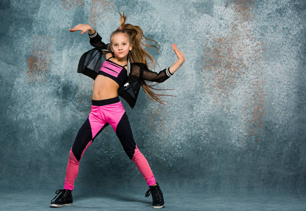 Young girl break dancing on wall background Young girl break dancing on gray wall stidio background. acrobatic gymnastics stock pictures, royalty-free photos & images