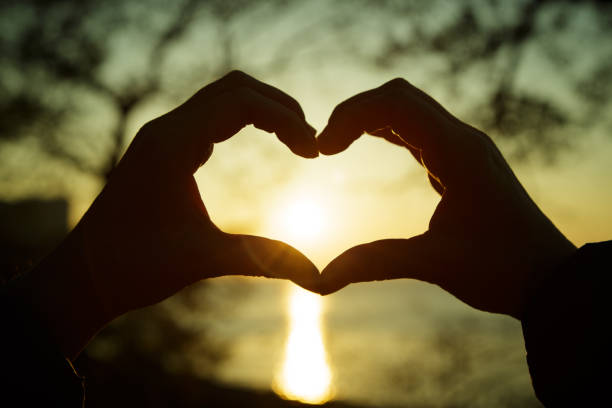 istock Heart from the combined hands against a sunset 651352948
