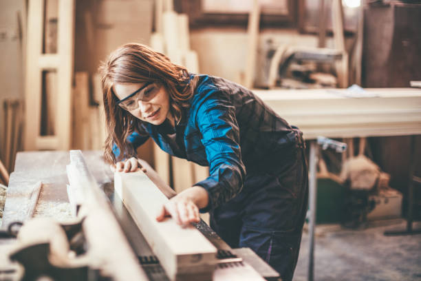 istock Redhead woman cutting a plank 651353232