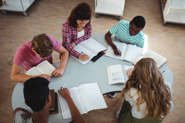 istock High angle view of attentive classmates studying in library 651353322