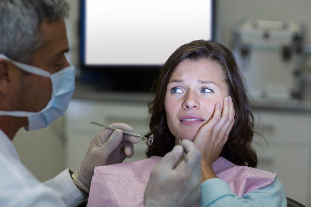istock Dentist examining a female patient with tools 651353436