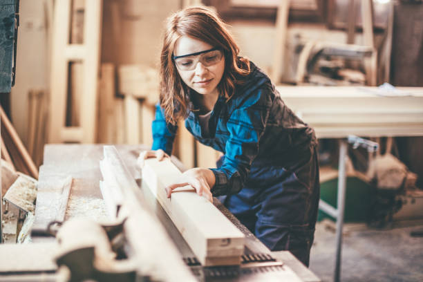 istock Redhead woman cutting a plank 651353648