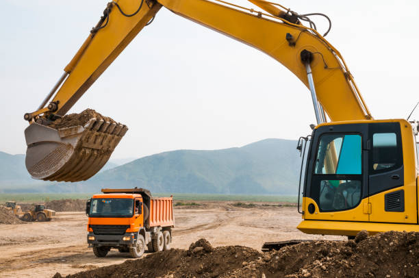 istock Loading of land ground in trucks using excavator 651354014
