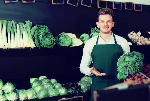istock Young male seller offering cabbage 651354362