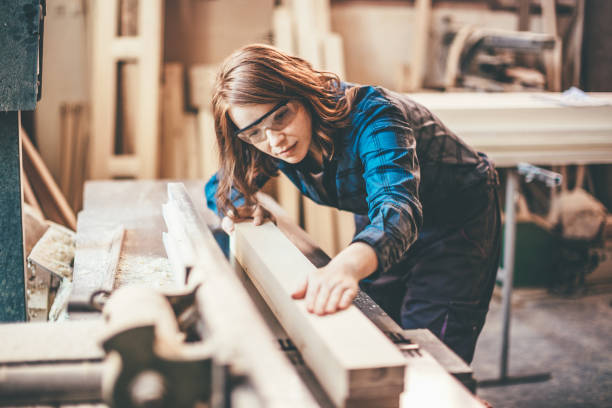 Redhead woman cutting a plank Redhead woman cutting a plank carpenter carpentry craftsperson carving stock pictures, royalty-free photos & images