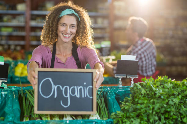istock Smiling staff holding organic sign board in organic section 651356690