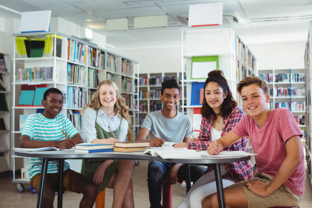 istock Portrait of happy classmates studying in library 651357300