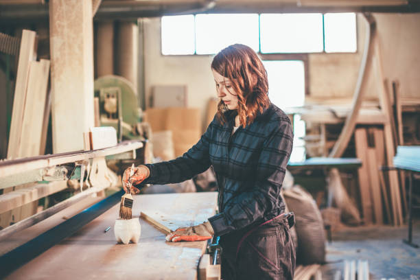 istock Woman carpenter inspecting freshly painted wood 651357570
