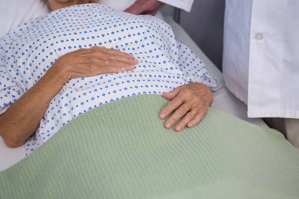 Nurse helping patient in hospital wheelchair. 