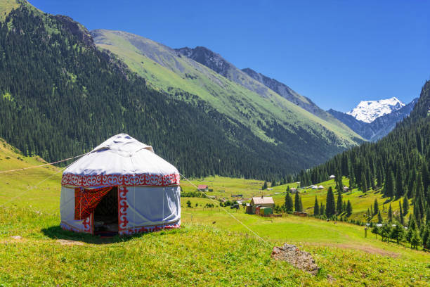White Yurt in the mountains of Kyrgyzstan. Beautiful mountain landscape with the white Yurt, decorated with a red ornament, Kyrgyzstan. yurt photos stock pictures, royalty-free photos & images