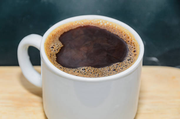istock White coffee cup with foam and bubbles, isolated wood background 651366078