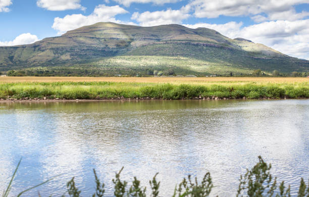 istock Rural pond with reflections from dappled sun through cloud sky 651399696