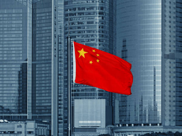Chinese flag with skyscrapers Photo of China national flag with modern skyscrapers in the background china stock pictures, royalty-free photos & images