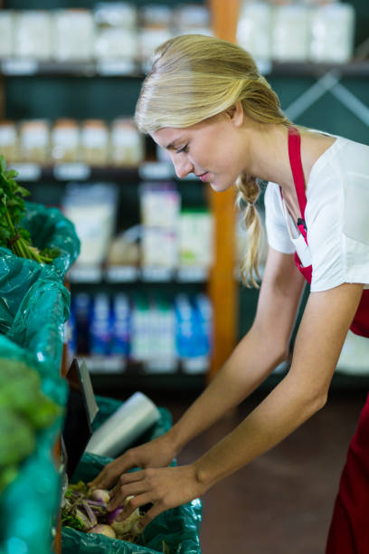 istock Female staff checking vegetables in organic section 651472770