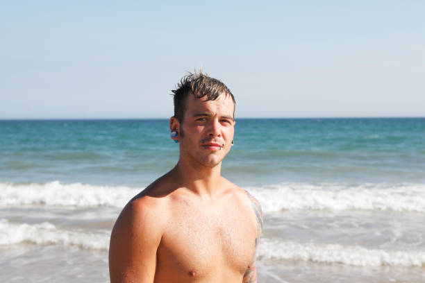 istock Portrait of a young white man on the beach 651487120