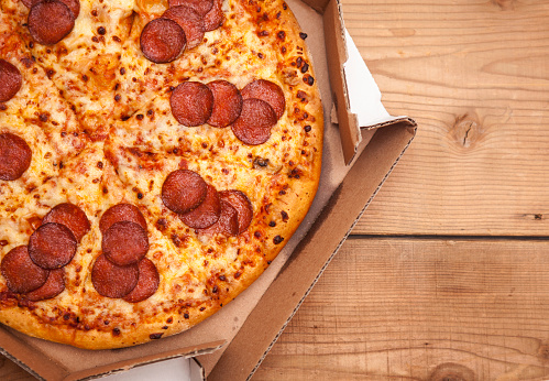 Hot Sliced Pepperoni Pizza In Delivery Box On Wooden Background With Copy Space