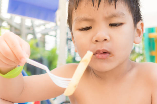 istock Asian boy is having fries snack on the beach 651496274