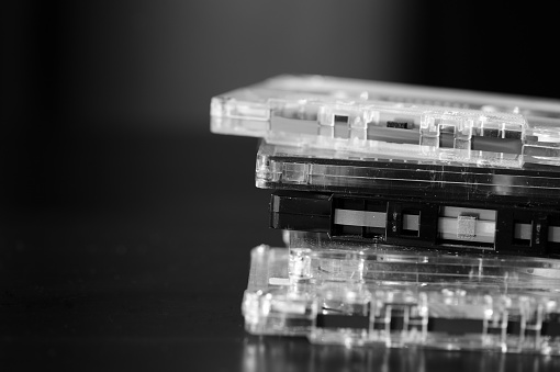 A stack of old audio cassettes. Black and White