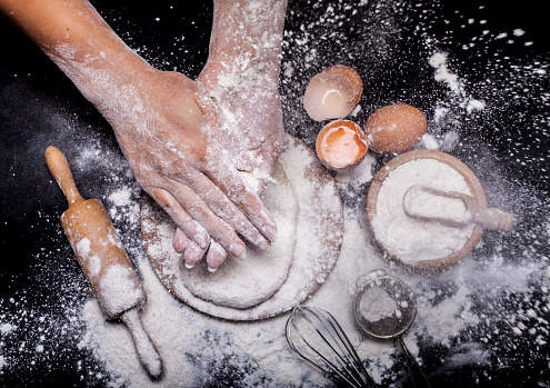 Baker prepares bread. Top view with copy space