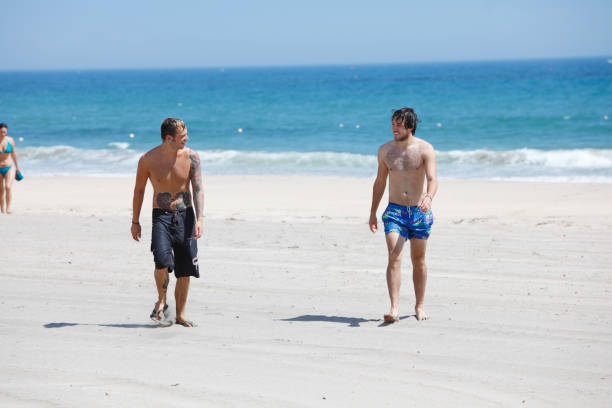 istock Young white male walking down the beach 651527584