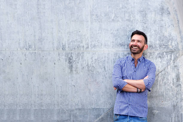 istock Cheerful mature man standing with arms crossed 651562696