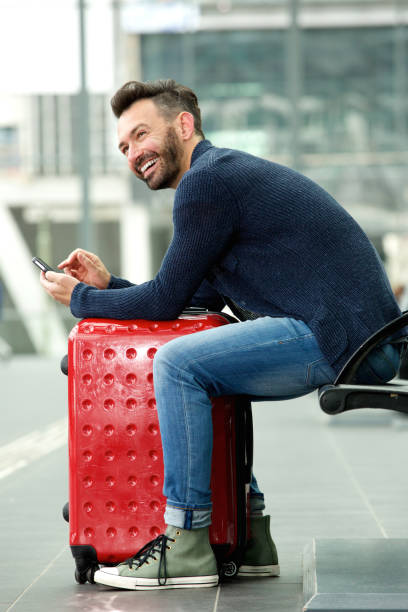 istock Smiling mature man waiting at train station 651563676