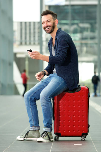 istock Smiling mature man waiting at train station 651565884