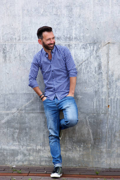 istock Stylish mature man standing against wall 651569366