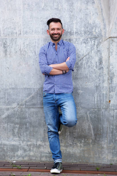 istock Confident mature man standing against wall 651569614