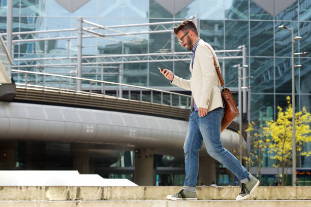 istock Happy caucasian man walking outdoors and reading text message 651570468