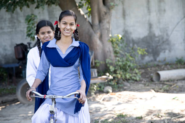 Schoolgirls on bicycle Portrait of Indian girls in school uniform on bicycle bicycle cycling school child stock pictures, royalty-free photos & images