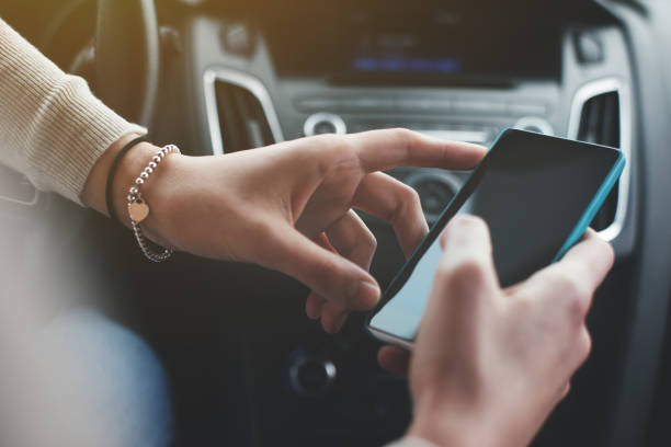 istock Woman's hands holding smartphone in car interior 651575592
