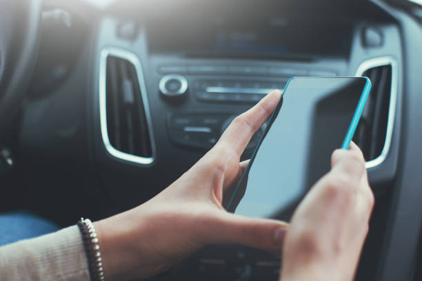istock Woman's hands holding smartphone in car interior 651575596