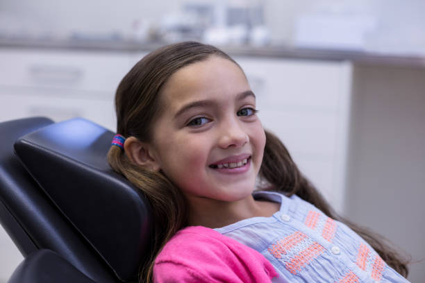 istock Smiling young patient sitting on dentists chair 651577080