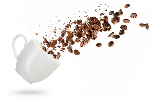 coffee beans spilled out of a coffee cup isolated on white background