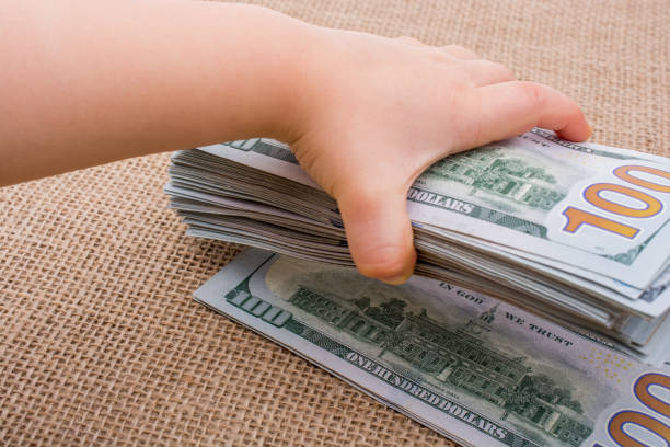 istock Toddler hand holding banknote bundle of US dollar in hand 651615368