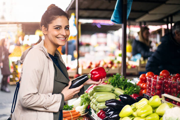 young cheerful woman at the market - tomato women green market imagens e fotografias de stock