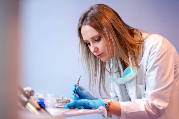 歯科医院で働く若い女性の歯科医。 - dental hygiene prosthetic equipment dentist office dental equipment ストックフォトと画像
