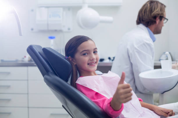 istock Smiling young patient sitting on dentists chair 651669742