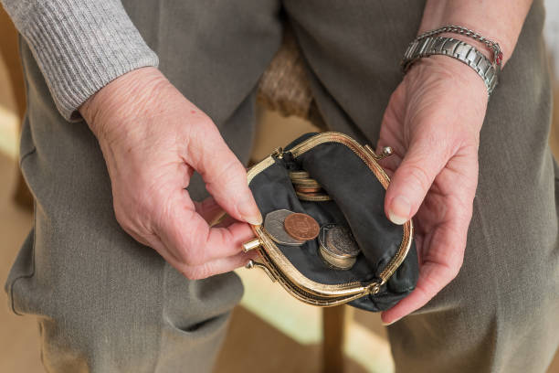istock Hands of a pensioner checking loose change in purse 651690516