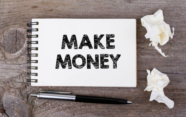 istock Make Money. On a wooden table notebook and pen 651691524