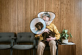 Man at Veterinarian Wearing Dog Cone