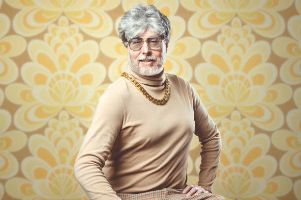 Retro Seventies Style Salesman A portrait of a man in 1970's style, posing in front of a vintage floral wallpaper background.  He wears a gold chain over a brown turtleneck sweater, a charming smile on his face.  Could also be a mobster or swinger character. offbeat stock pictures, royalty-free photos & images