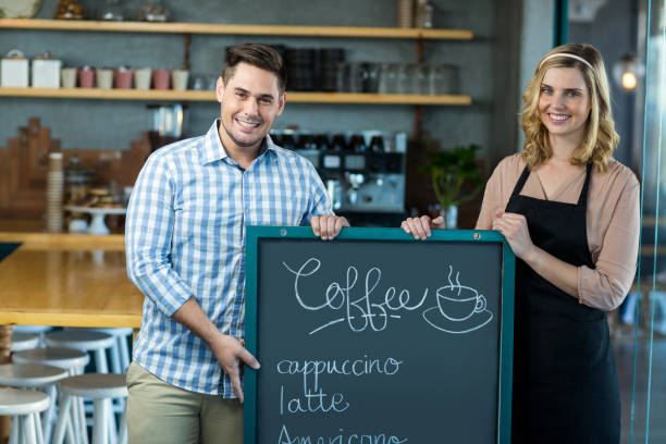 istock Waitress and man standing with menu board in cafe 651754176