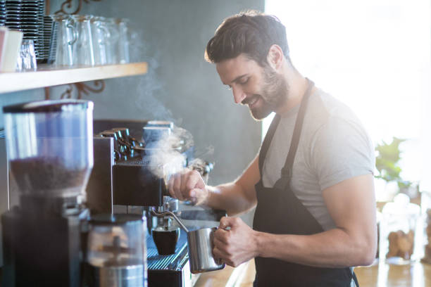 istock Smiling waiter making cup of coffee 651757358